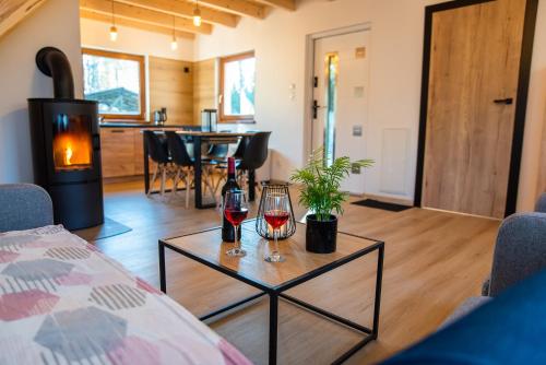 a living room with two glasses of wine on a table at Domek Julia z banią ruską i sauną in Sulęczyno