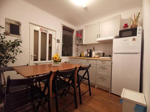 a kitchen with a table and chairs and a refrigerator at Casa Bunicilor Sinaia in Sinaia