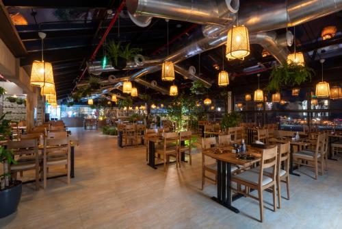 a restaurant with wooden tables and chairs and lights at Golden Tower Hotel Al Khobar Corniche in Al Khobar