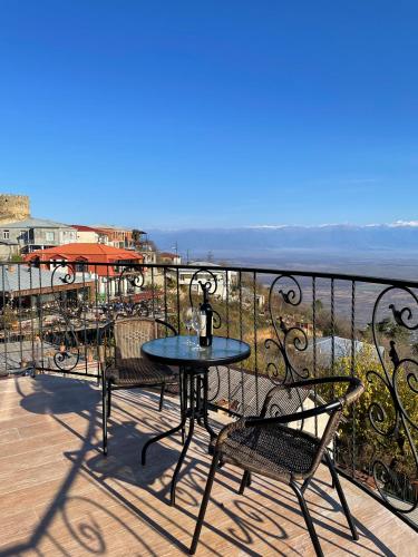a table and chairs on a balcony overlooking the ocean at Guest House Kusika in Sighnaghi
