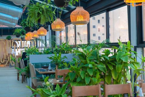 a restaurant with potted plants and lights at Golden Tower Hotel Al Khobar Corniche in Al Khobar