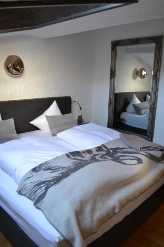 a bedroom with a large bed with a large mirror at Andys Bergjuwel in Leutasch