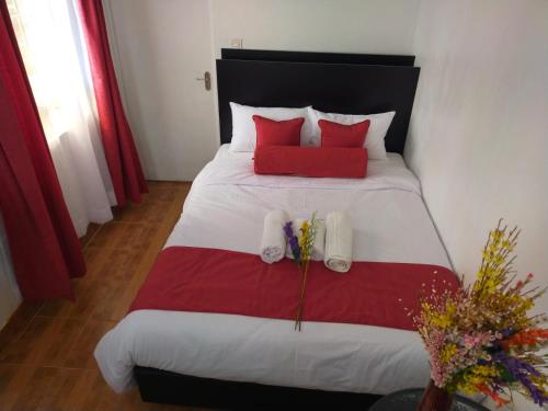 a bedroom with a large bed with red pillows at Bloom 2 private home in Thika