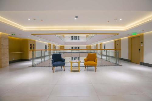 a hallway with two chairs and a table in a building at IKON By Annapoorna in Coimbatore