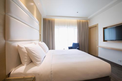 a hotel room with a large bed and a television at IKON By Annapoorna in Coimbatore