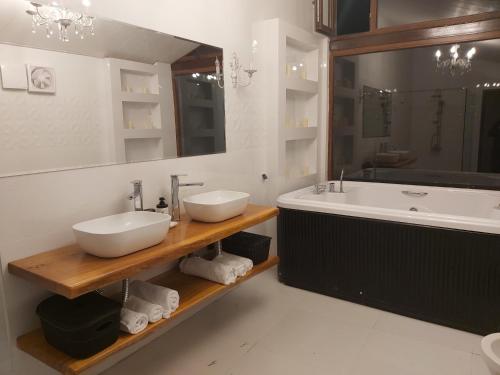 a bathroom with two sinks and a tub and a sink at Guest House Kusika in Sighnaghi