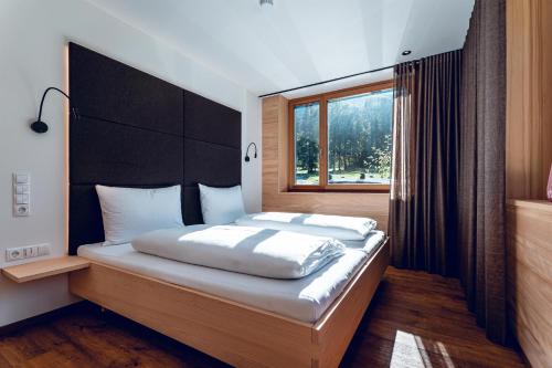 a bedroom with a large bed with a window at Scheune Valfontana in Vandans