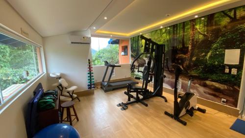 a gym with exercise equipment in a room with an aquarium at Kaliman Pousada in Ubatuba
