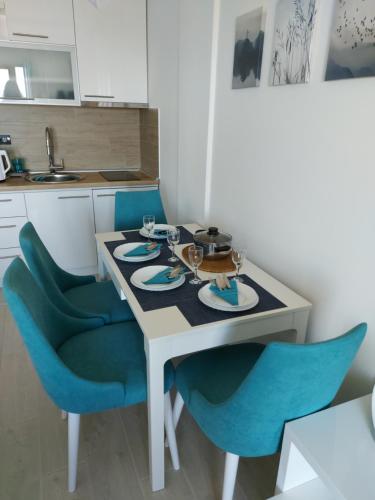 a kitchen with a table and blue chairs at Ivkovic spa Milmari N16 in Kopaonik