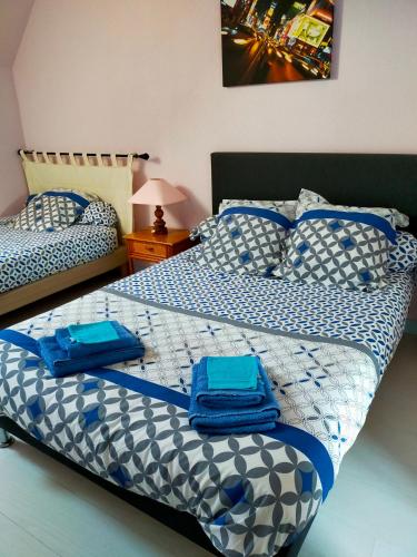 une chambre avec un lit avec des serviettes bleues dessus dans l'établissement La petite maison bleue, à Lopérec