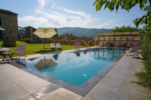 a swimming pool with chairs and an umbrella at Alba Morus Bed & Breakfast sentiti a casa nel cuo in Arezzo