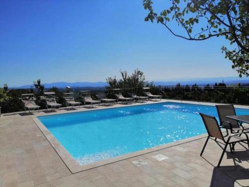 a large swimming pool with chairs and a table at B&B L'amicizia in Montefiascone