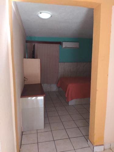 a small room with a red bed in a room at Hotel Duve Coral in Loreto