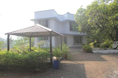 ein weißes Haus mit einem Pavillon davor in der Unterkunft Ivy Maitri Farm 3 Bhk with Private Pool - Badlapur in Badlapur