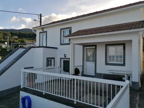 a white house with a white railing and a balcony at Casa da Isabel in São Roque do Pico