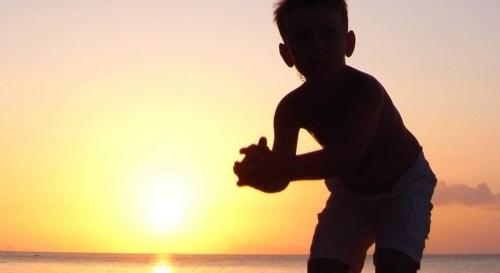 a young boy running on the beach at sunset at Jasmine & Tea House in Mae Nam