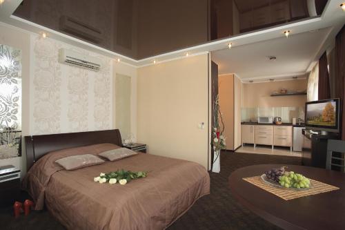 a bedroom with a bed and a table with flowers on it at Vizavi Apartments in Yekaterinburg