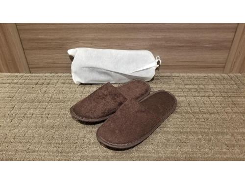 a pair of brown slippers on a bed with a purse at Onomichi Kokusai Hotel - Vacation STAY 87041v in Onomichi