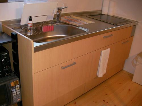 un bancone della cucina con lavello e forno a microonde di Gujo Cottage Ryukobashi no Hotori - Vacation STAY 88697v a Gujo