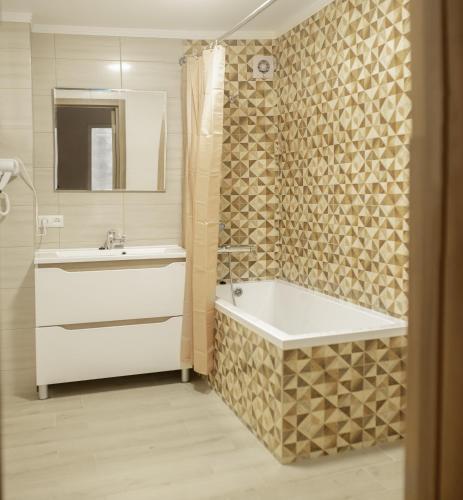 a bathroom with a tub and a sink and a shower at ART Apartment in Mukacheve