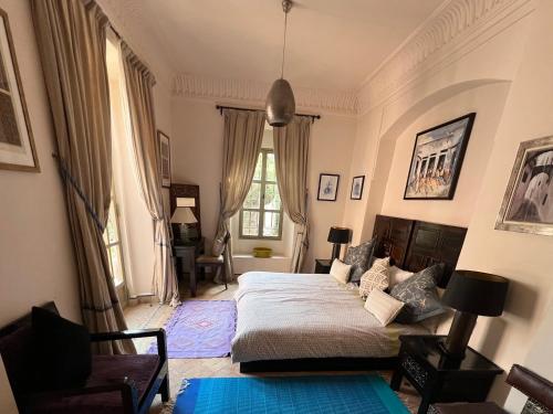 a bedroom with a bed and a chair and a window at Villa #1 ‘Rosalie’ in Marrakech
