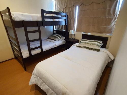 a bedroom with two bunk beds and a window at Hotel Capelli Express in Talca