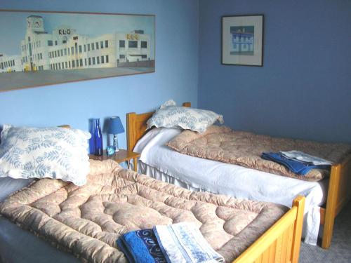 two beds in a room with blue walls at Les Chimères in Puylaroque