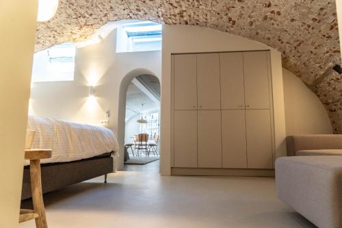 ein Schlafzimmer mit einem Bett und einer Decke mit einem Bogen in der Unterkunft Vlinder's in Utrecht