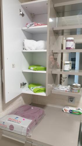 a white cabinet filled with lots of items in a room at Temi's Apartments 2 in Skopje