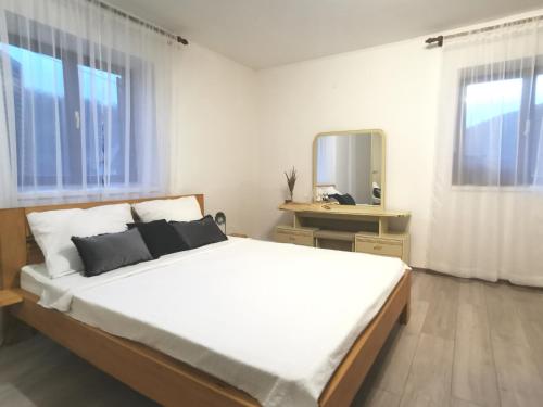 a bedroom with a large white bed and a mirror at Kuća za odmor Kupa in Vrbovsko