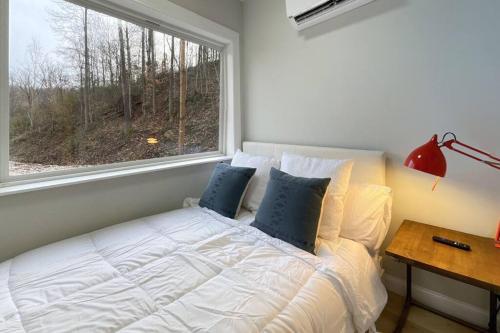Schlafzimmer mit einem Bett, einem Fenster und einem Schreibtisch in der Unterkunft The Hideaway on Tacketts - Shipping Container in Hurricane