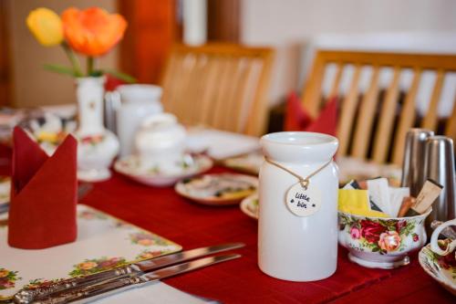 een tafel met een witte vaas op een rode tafeldoek bij Tanes Hotel in Cardiff