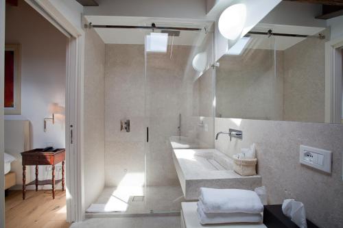 a bathroom with a large shower and a sink at Relais Corte Guastalla Apartments in Sona