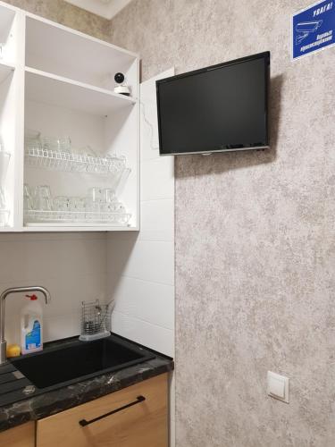 a kitchen with a tv on a wall at Hostel "Гном & Gnome" in Lviv