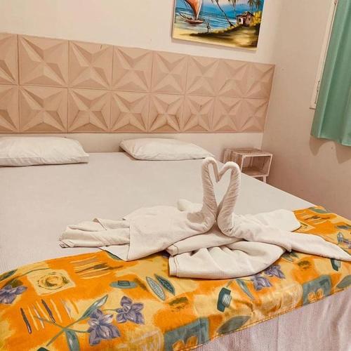 a bed with towels on top of it at Portal Cores in Porto De Galinhas