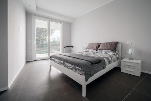 - une chambre blanche avec un lit et une fenêtre dans l'établissement Appartamento Scirocco, à Riccione