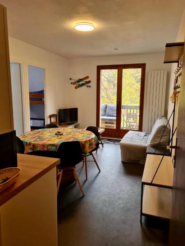 Cette chambre comprend un lit, une table et un canapé. dans l'établissement Très joli appartement 4-6 personnes dans Luchon, à Luchon