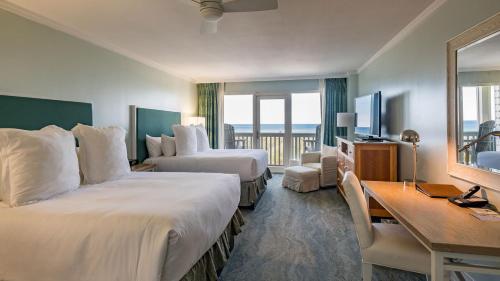 a hotel room with two beds and a desk at WaterColor Inn & Resort in Santa Rosa Beach