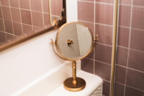 a mirror sitting on top of a toilet in a bathroom at CIVILIAN Hotel in New York