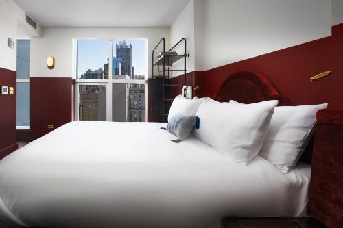 a bedroom with a large white bed with a window at CIVILIAN Hotel in New York