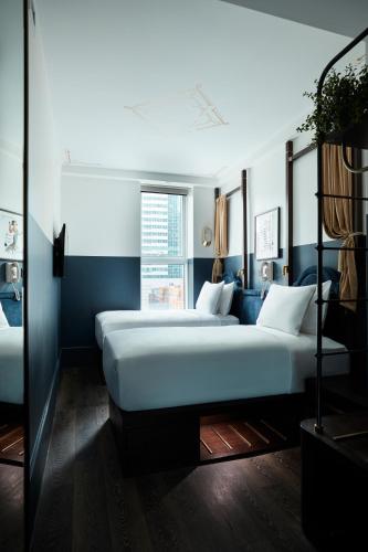 two beds in a room with blue walls at CIVILIAN Hotel in New York