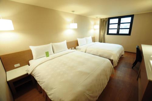 Tempat tidur dalam kamar di Kindness Hotel - Kaohsiung Main Station