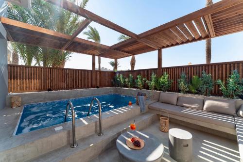 una piscina en un patio trasero con pérgola en Oasis Hotel Prasonisi en Prasonisi