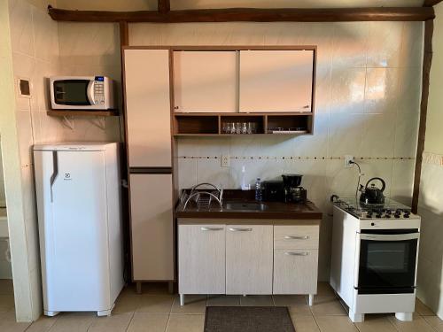 Una pequeña cocina con nevera y microondas. en Casa entre dois mares - Casa Bege, en Bombinhas