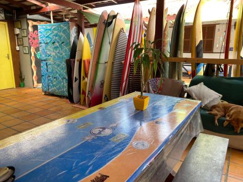 una mesa en una habitación con un montón de tablas de surf en Hostel Surf de Bem en Florianópolis