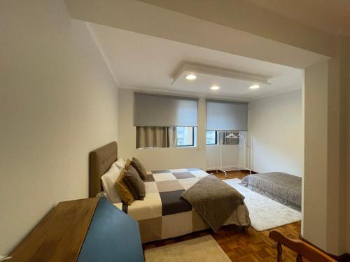 a bedroom with a bed and a table in it at PRAÇA AL in São João da Madeira
