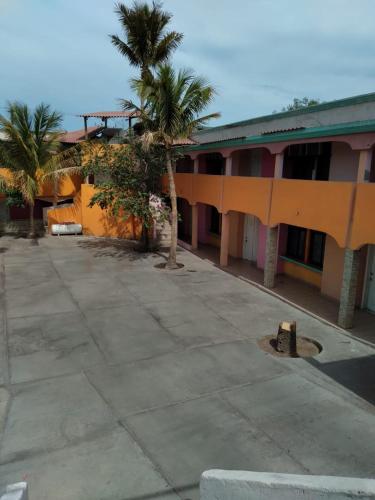 a building with palm trees in front of it at Hotel Duve Coral in Loreto
