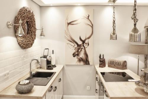 a kitchen with a sink and a deer head on the wall at HOME Suites Apartment 5 in Braunlage