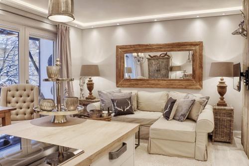 a living room with a couch and a mirror at HOME Suites Apartment 5 in Braunlage