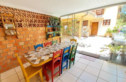 una sala da pranzo con un lungo tavolo e sedie di Nossa Guarda Acomodações a Guarda do Embaú